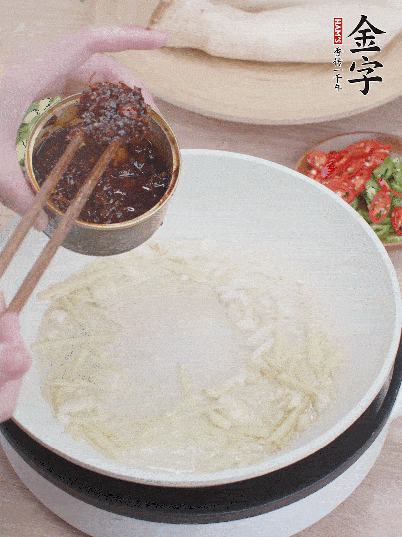 起鍋熱油，姜蒜、金字火腿干貝醬煸香。