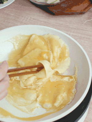 油6成熱時(shí)，下雞蛋液，邊緣凝固時(shí)翻拌成塊狀。