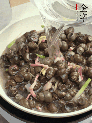 倒處理干凈的螺螄翻炒，加3勺料酒。加清水蓋過螺螄，中火蓋蓋煮5分鐘。