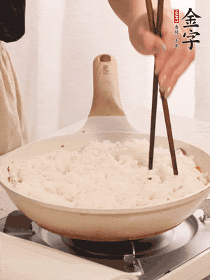 把瀝干水分的米飯均勻鋪在上面，筷子戳幾個(gè)洞，以便透氣，轉(zhuǎn)小火蓋上蓋子燜至水分收干，大概10分鐘。